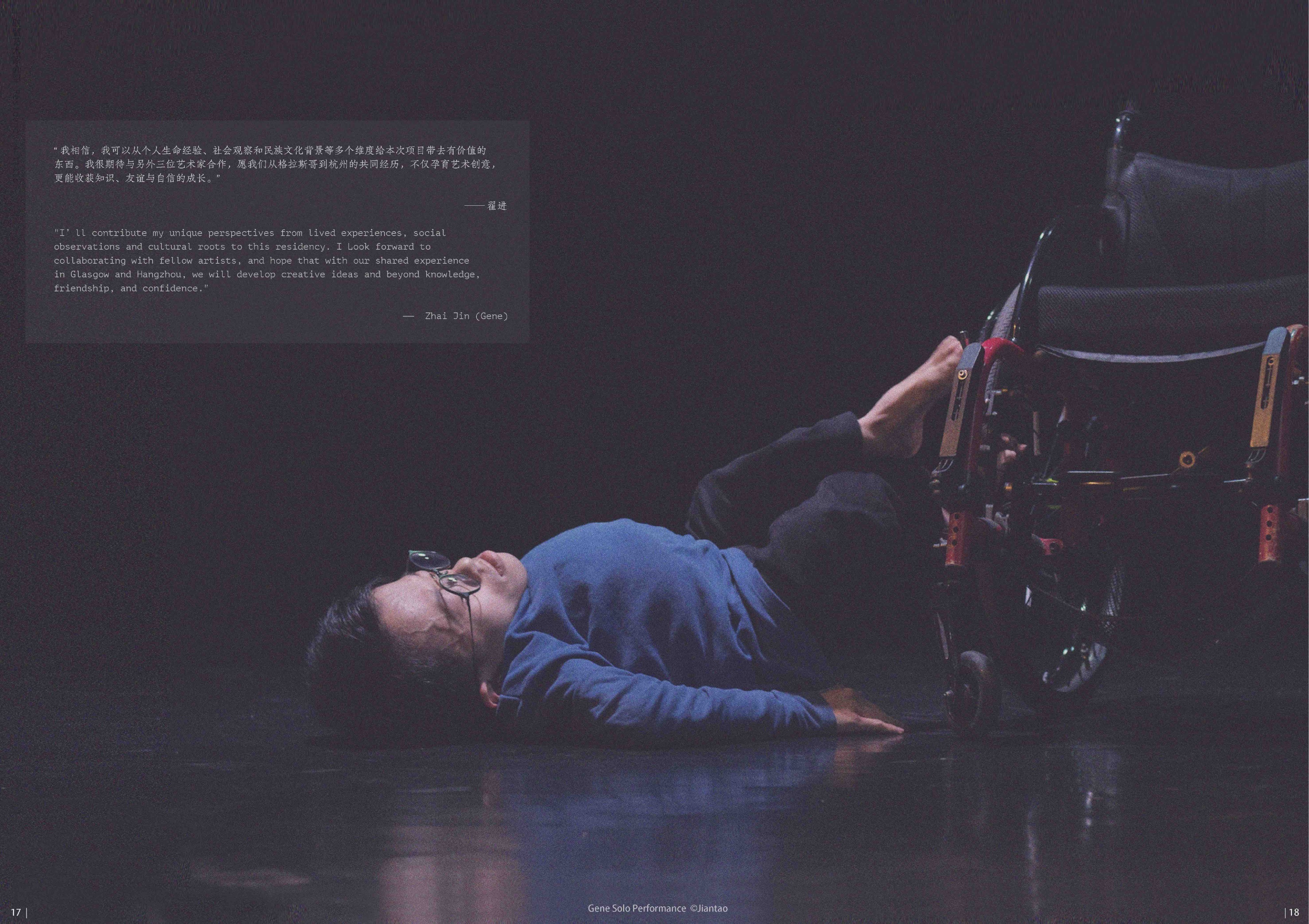 A performer lying on a dark stage