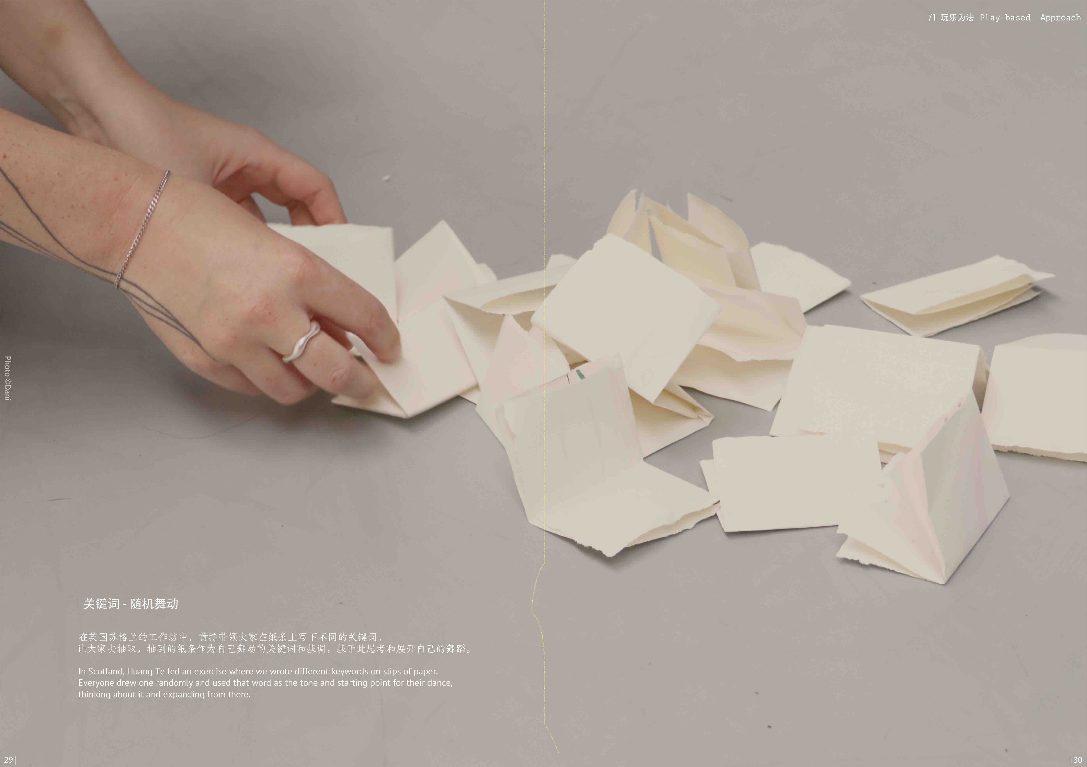 Hands folding small sheets of paper