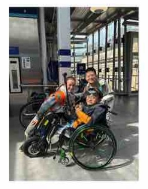A wheelchair user beside stone buildings
